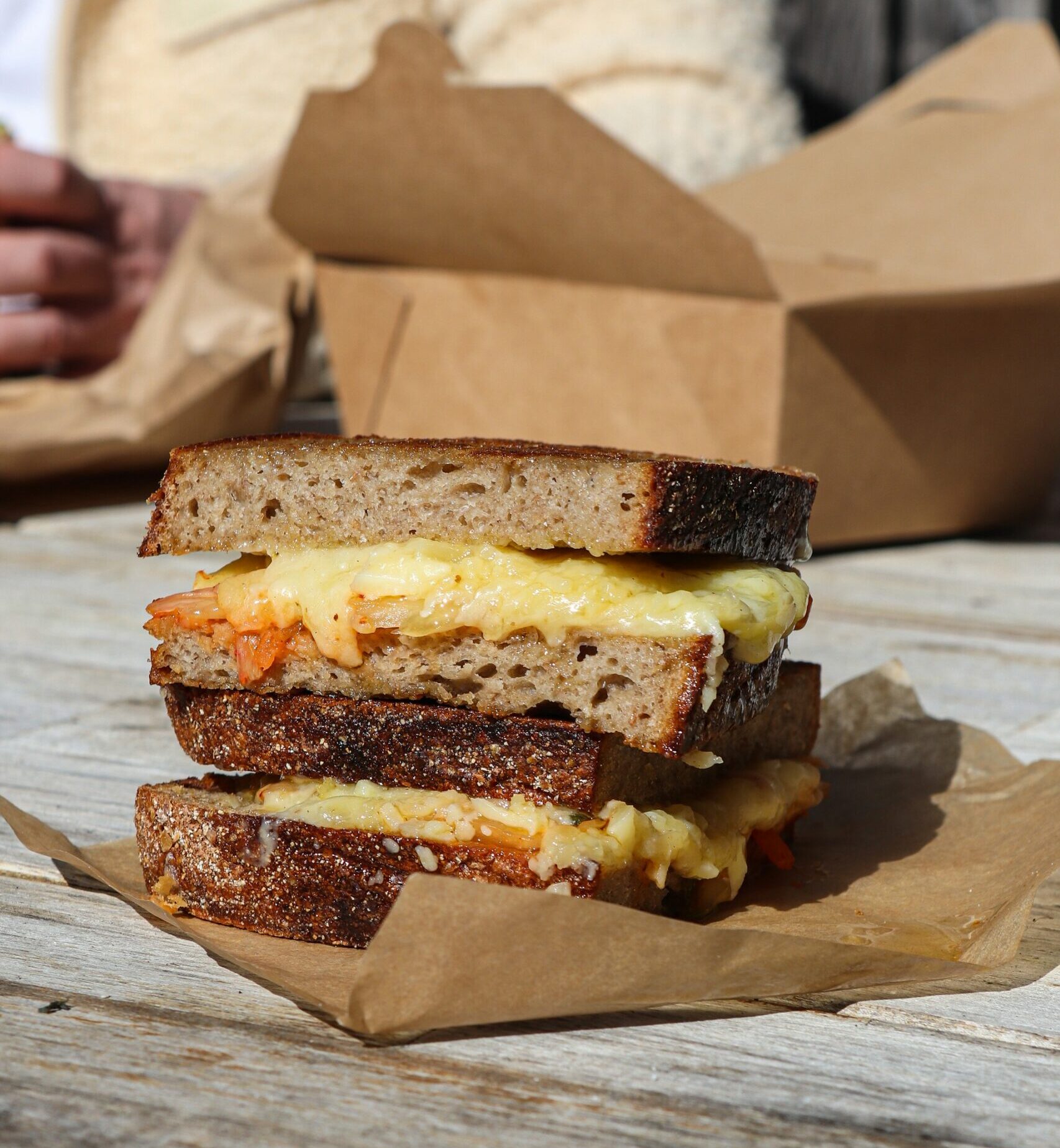 Cheese toastie sandwich cut in half on a piece of paper.